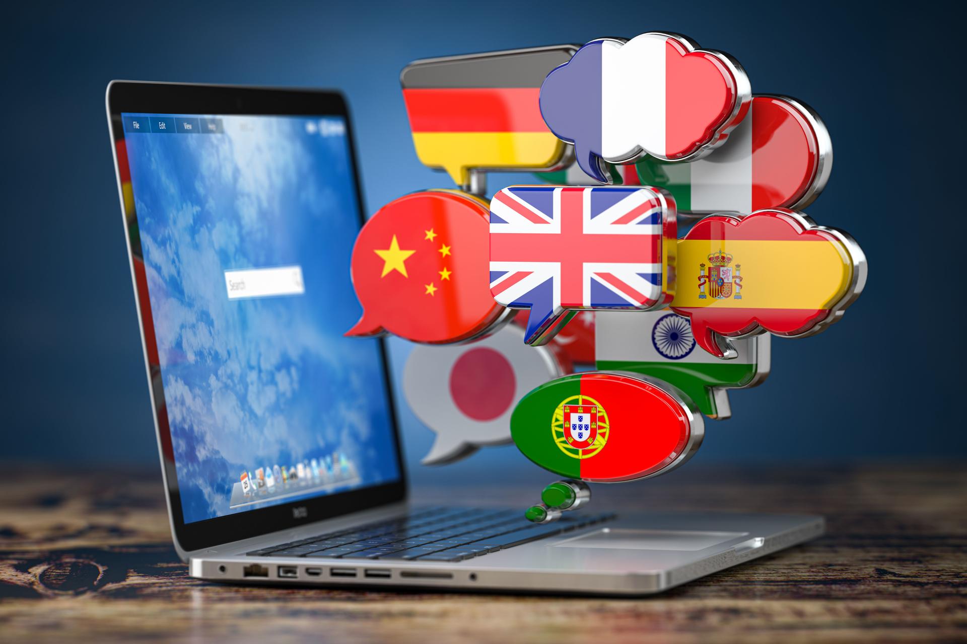 Global communication, dictionary, translating  and learning languages online app concept. Laptop and speech bubbles with flags.